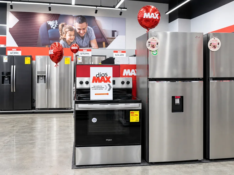 Afiche de la Semana HP sobre una mesa de exhibición de laptops en una tienda MAX