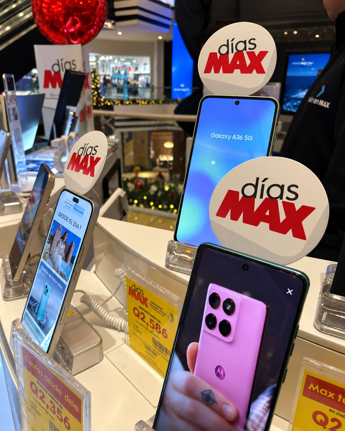 Phone tags de Días MAX junto a teléfonos en exhibición
